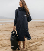 Woman wears a watersports changing robe from Finisterre with full length zip, water repellent fabric and side pockets