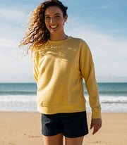 Woman wears a yellow sweatshirt from Finisterre, made from lightweight hemp and polyester blend 